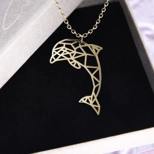 Goldene Origami Delfin Kette aus Edelstahl von Cherami auf schwarzem Schmuckhintergrund